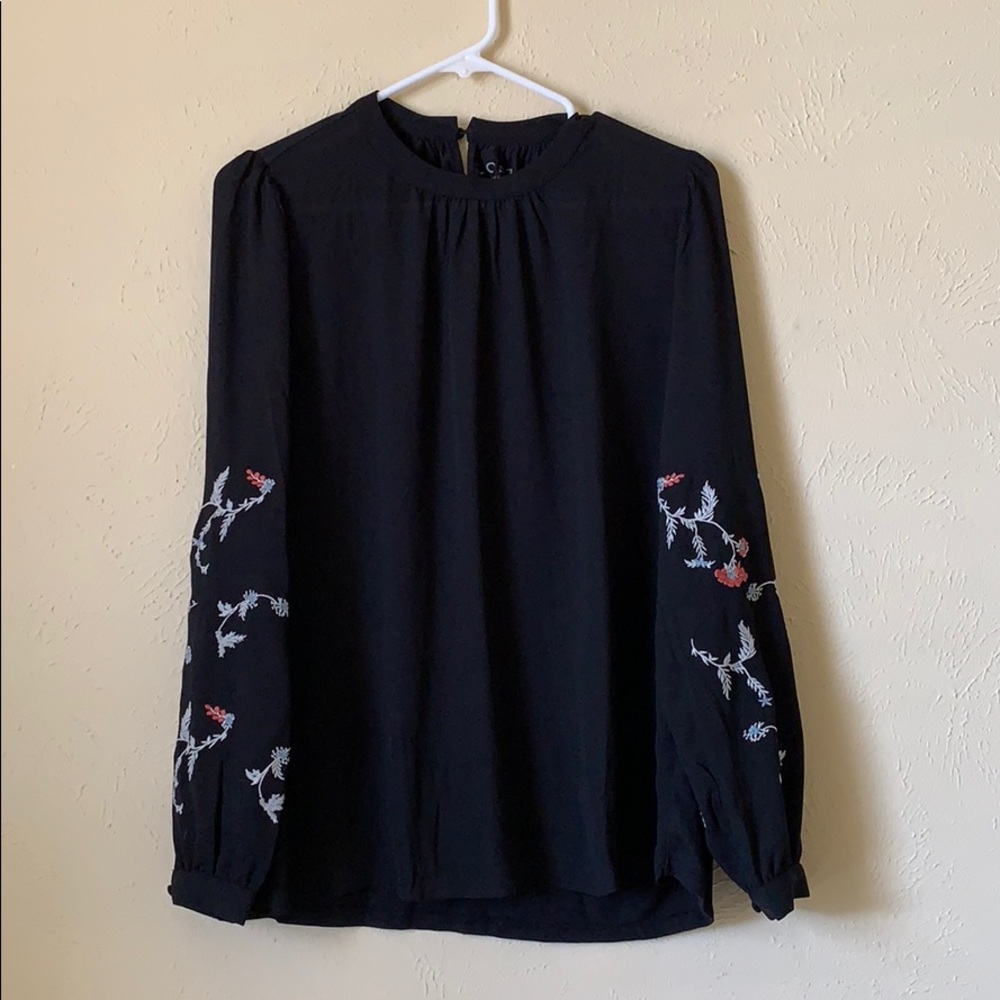 High collar elegant top with billowy sleeves.
